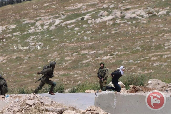 Photo of Israeli forces the teen running away from soldiers moments before he is shot to the ground.