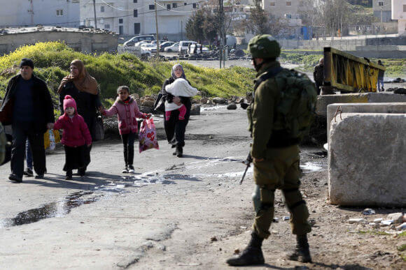 Palestinians make their way through an Israeli checkpoint at the Palestinian al-Fawwar refugee camp, south of the West Bank city of Hebron, on February 21, 2019. (Photo: Wisam Hashlamoun/APA Images)