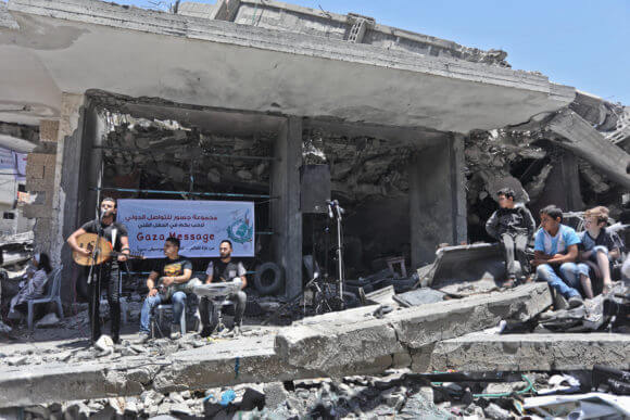Children watch the concert in the ruins of the al-Qamar building (Photo: Mohammed Asad)