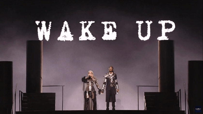 Madonna and Quavo stand under the words "Wake Up" at the end of the Eurovision performance of their song “Future.” (Photo via Twitter/@madonnatribe)