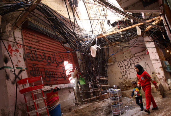Palestinians walk in an alley in one of the most densely populated Palestinian refugee camps in Lebanon, Burj al-Barajneh, March 5, 2012. (Photo: Mohammed Asad/APA Images)