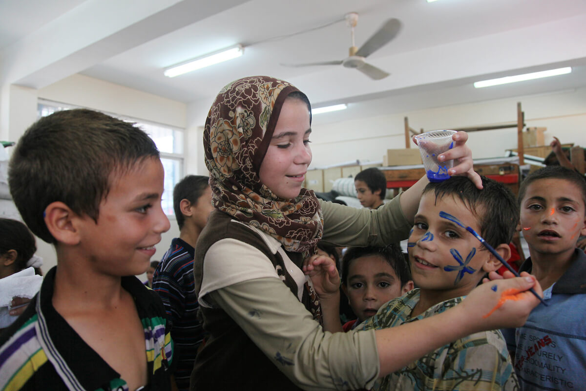 Palestinian children affected by the war attend a group class as part of the United Nations community mental health programmes in the Gaza Strip on August 2, 2014 at a school converted to a refuge in Jabalia, in the north of the Gaza strip. "To prevent children from processing and thinking about all these issues we try to distract them, to help them live some joy, to have a little fun inside the shelter", said psychiatrist Dr. Iyad Zaqout, who manages the program. (Photo: Ezz al-Zanoun/APA Images)