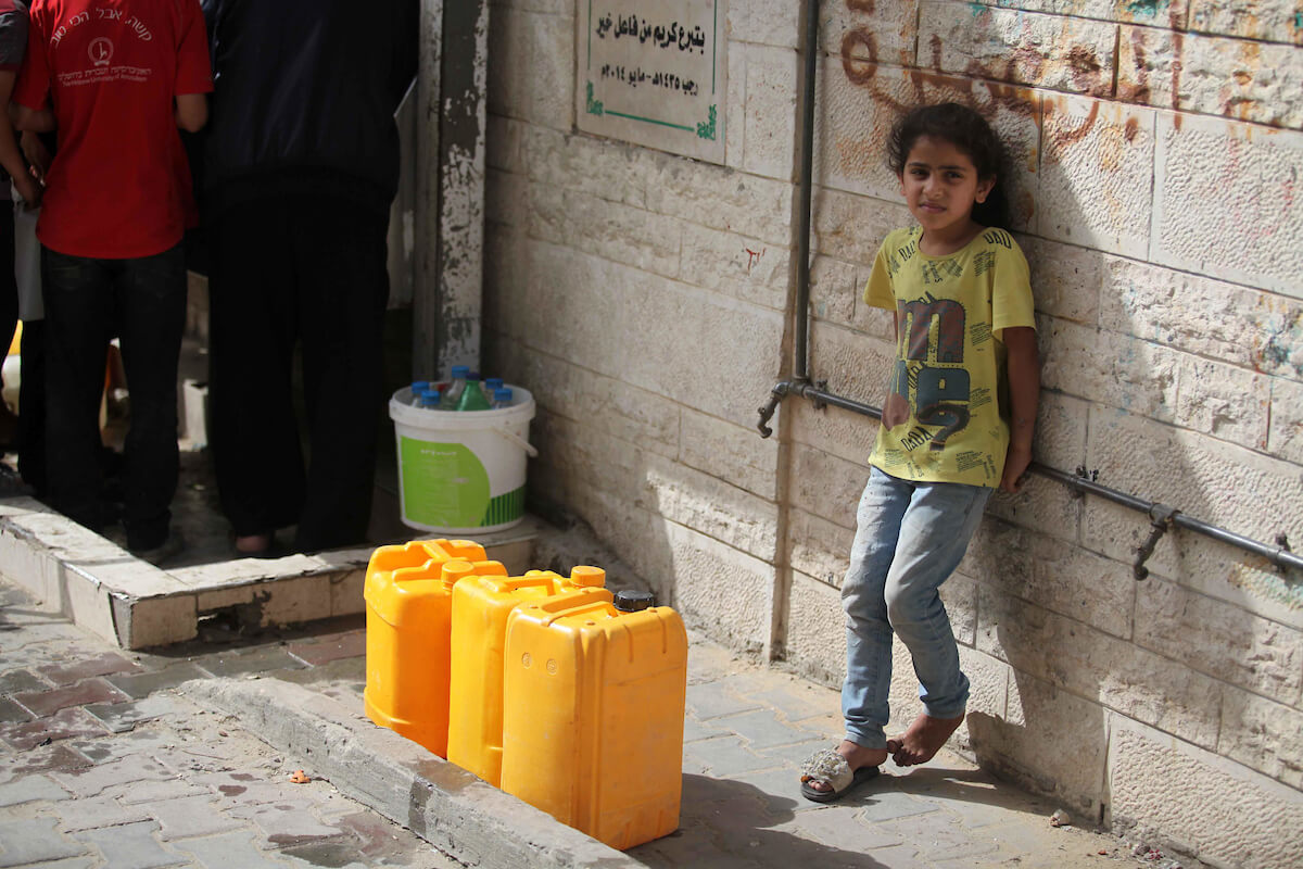 Palestinians fill their bottles and jerry cans with drinking water from a public tap during a heatwave in al-Shati refugee camp, west Gaza city on May 23, 2019. (Photo: Mahmoud Ajjour/APA Images)