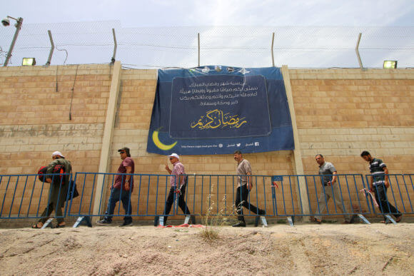 Palestinians are turned away from Qalandiya checkpoint after being forbidden from crossing over to Jerusalem. The sign reads: “Ramadan kareem” and signed by the Israeli civil administration coordinator.