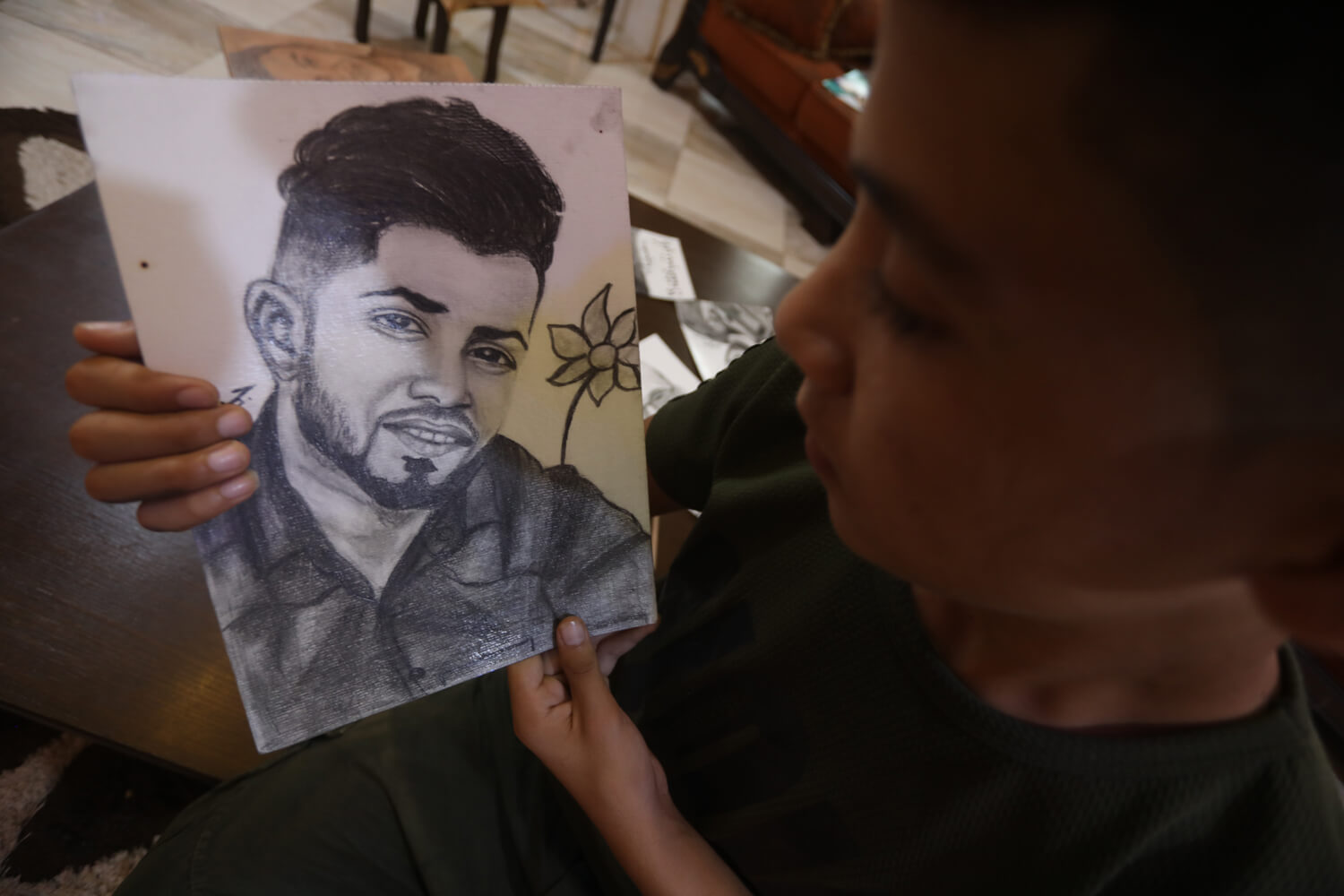 Jamil holding a portrait of his friend, Tamer Abu al-Khair.