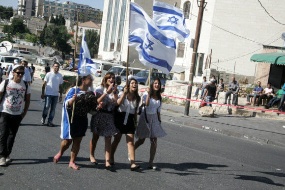 Israelis wave their national flag on July 1, 2011 as some 40,000 march in a Jerusalem Day parade in the city's Arab neighborhoods to celebrate the capture of Jerusalem during the Six Day War in June 1967. (Photo: Mahfouz Abu Turk/APA Images)