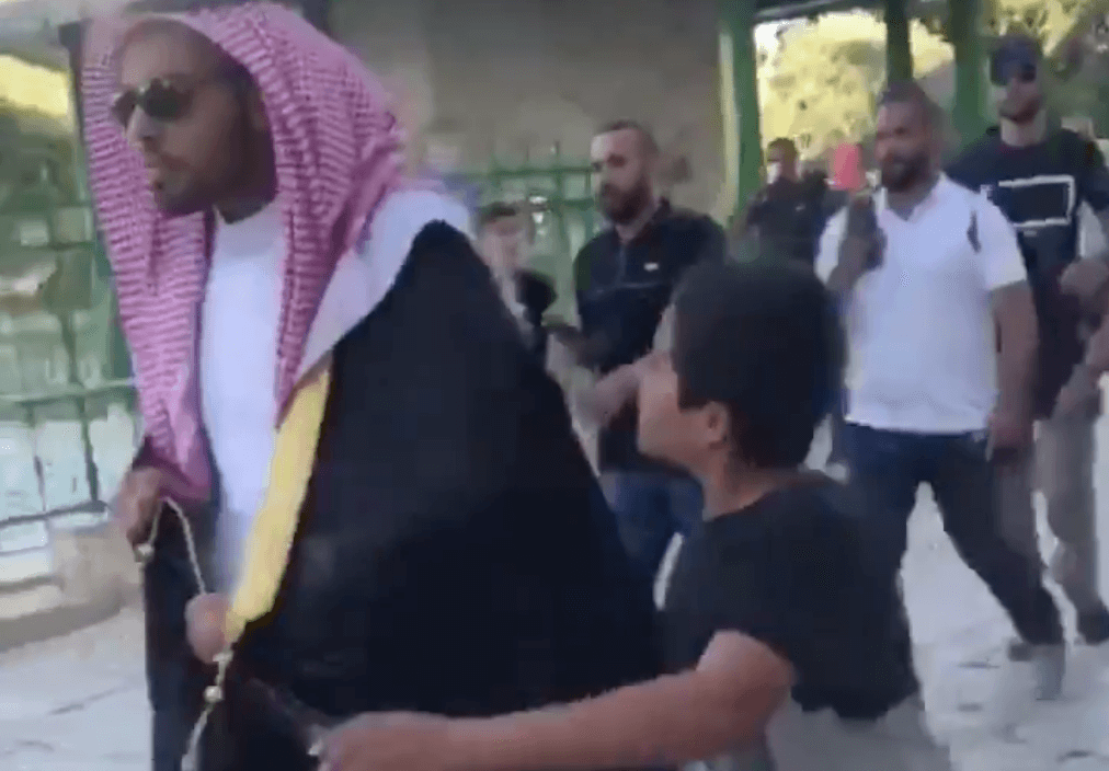 A Palestinian child approaches Saudi blogger Mohammed Saud to spit on him as he visits the Old City of Jerusalem on an Israeli government delegation.