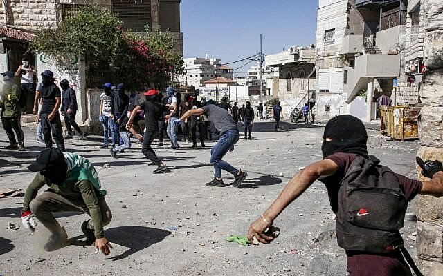 Palestinians throw stones during clashes with Israeli police in Jerusalem's neighborhood of Issawiya on June 28, 2019, a day after a Palestinian was shot and killed by police during a protest in the same neighborhood. (Hazem Bader/AFP)