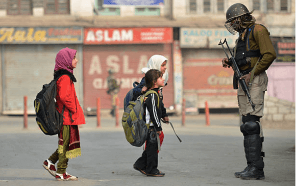 Kashmiri children walk past Indian paramilitary troopers as they stand guard during curfew and restrictions in downtown Srinagar, November 11, 2016. (Photo: Tauseef Mustafa/ AFP/ Getty Images)