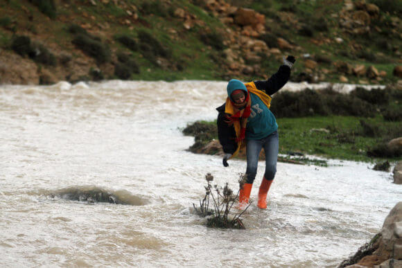 A Palestinian girl passes through flooding water in the village of Ein Qiniya near the West Bank city of Ramallah, Jan. 9, 2013. Extreme weather, including torrential rains and heavy winds, killed four people in Israel and the Palestinian territories on January 8, 2013, as widespread flooding swept the Middle East. (Photo: Issam Rimawi/APA Images)