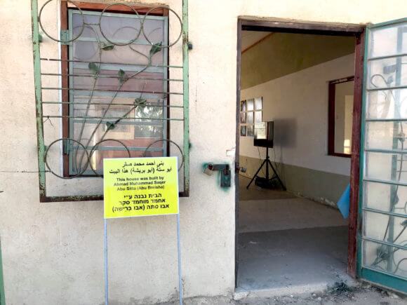 A sign describing the house where the Ma'in exhibit took place. The house was build by Abu Breisha, yet, some Israelis insist the British built it. (Photo: Eléonore Merza Bronstein)