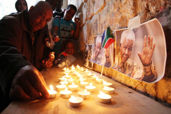 Palestinians gather at a candle memorial for late South African President Nelson Mandela in the African quarter of Jerusalem's Old City, 07 December 2013. (Photo: Saeed Qaq/APA Images)