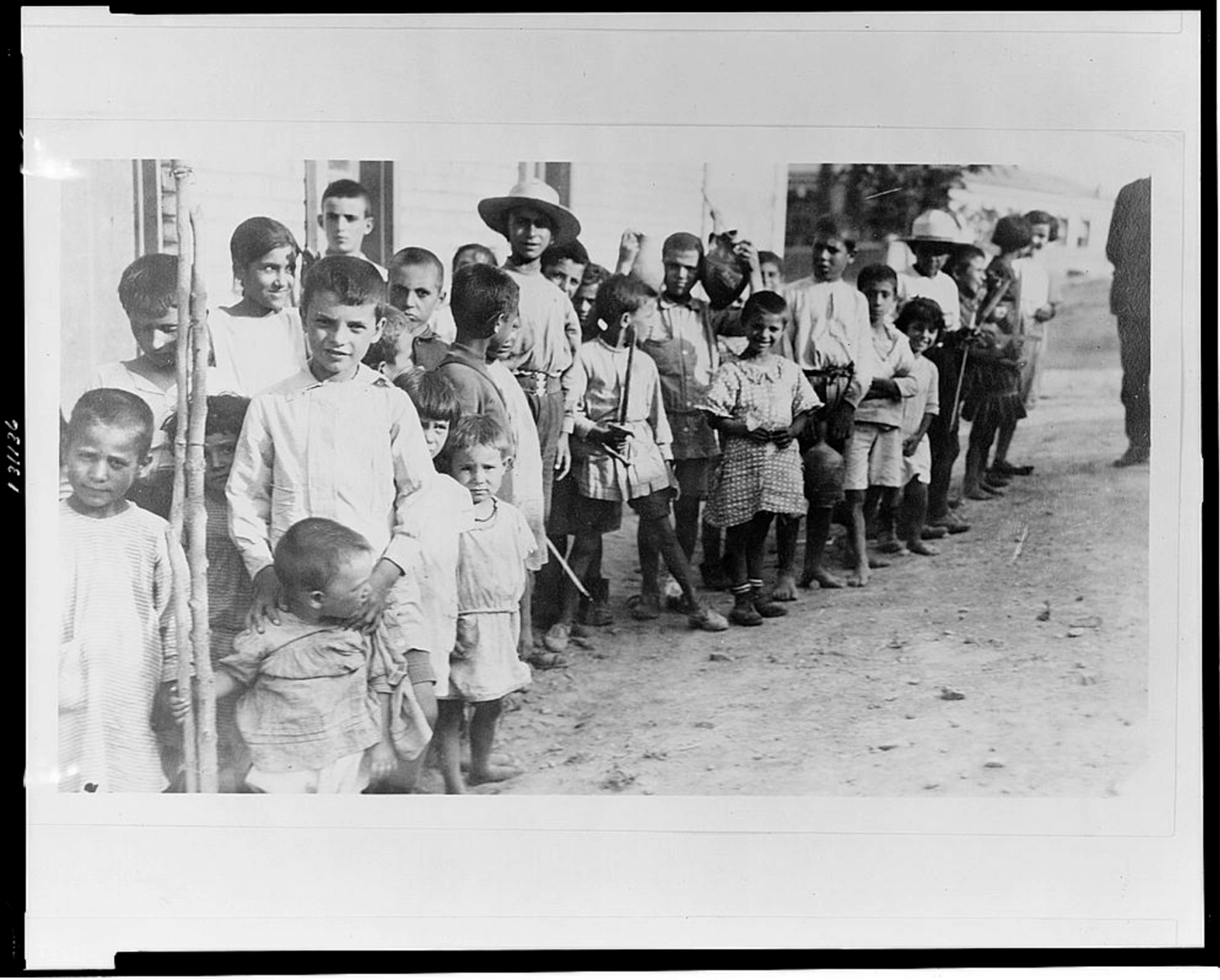 (1923) Greek and Armenian refugee children from Anatolia standing outside one-story building, near Athens, Greece. Greece, 1923. [Photograph] Retrieved from the Library of Congress, https://www.loc.gov/item/2002709161/.