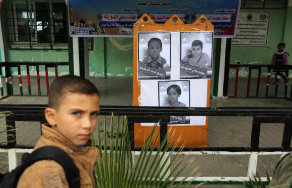 Palestinian students look on the pictures of members of Sawarka family who were killed by an Israeli airstrike, at their school, in Deir al-Balah, central of Gaza Strip on November 16, 2019. (Photo: Ashraf Amra/APA Images)
