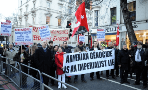 Supporters of the government of Turkey stage a rally in France. Their sign reads "The Armenian Genocide is an Imperialist Lie"