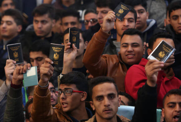 Palestinians hold their passports as they wait for travel permits to cross into Egypt through the Rafah border crossing after it was opened by Egyptian authorities for humanitarian cases, in the southern Gaza Strip December 17, 2017. (Photo: Ashraf Amra/APA Images)