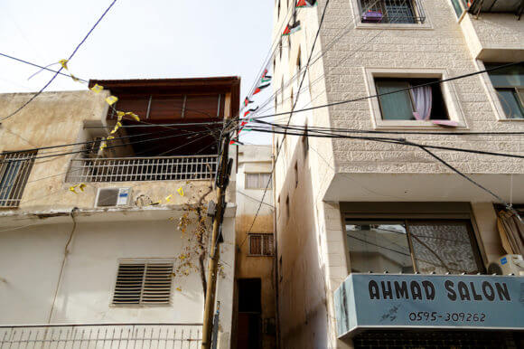 Power lines in Qadura refugee camp in the West Bank city of Ramallah are spliced and shared with multiple households and shops. Although electrical service in the camps is the responsibility of the Palestinian Authority, it has not paid down the bill since 2014. (Photo: Miriam Deprez)