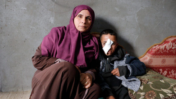 Muhammad Abu Raidah, 10, with his mother Jihan. (Photo: B'Tselem)