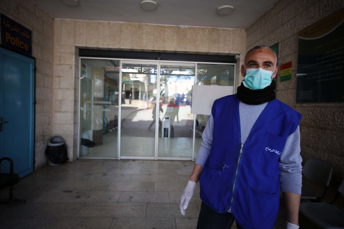 A Palestinian man wears a mask as a preventive measure against the Coronavirus stands outside Beit Jala governmental hospital, in the West Bank city of Bethlehem on March 5, 2020. The Palestinian health ministry called for local churches, mosques and other institutions to close after a number of suspected cases of coronavirus COVID-19 at a hotel in the Holy Land city of Bethlehem. (Photo: Abedalrahman Hassan/APA Images)