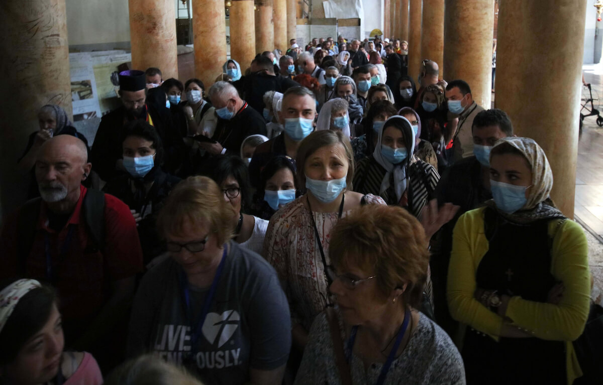 Foreign tourists wearing masks as a preventive measure against the coronavirus during a visit to the Church of the Nativity, in the West Bank city of Bethlehem on March 05, 2020. (Photo: Abedalrahman Hassan/APA Images)