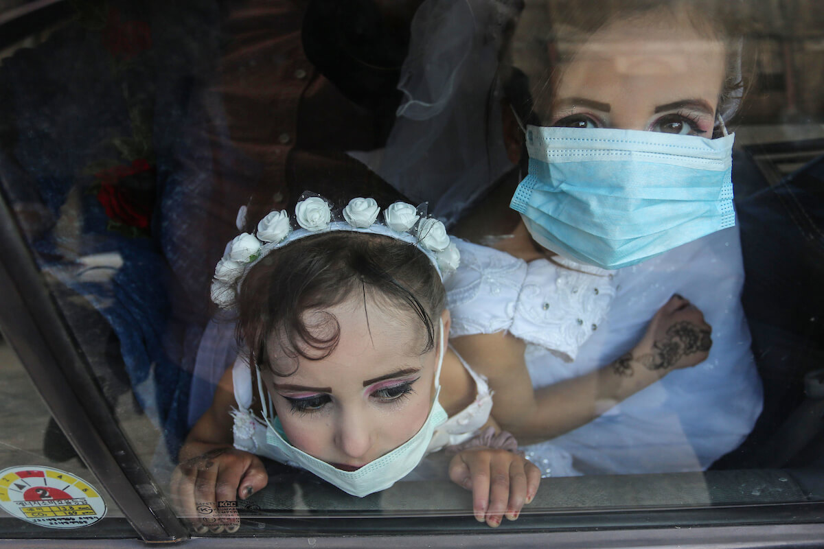 Palestinian girls wear face masks during a wedding in Khan Younis in the southern of Gaza Strip, on March 22, 2020. (Photo: Ashraf Amra/APA Images)
