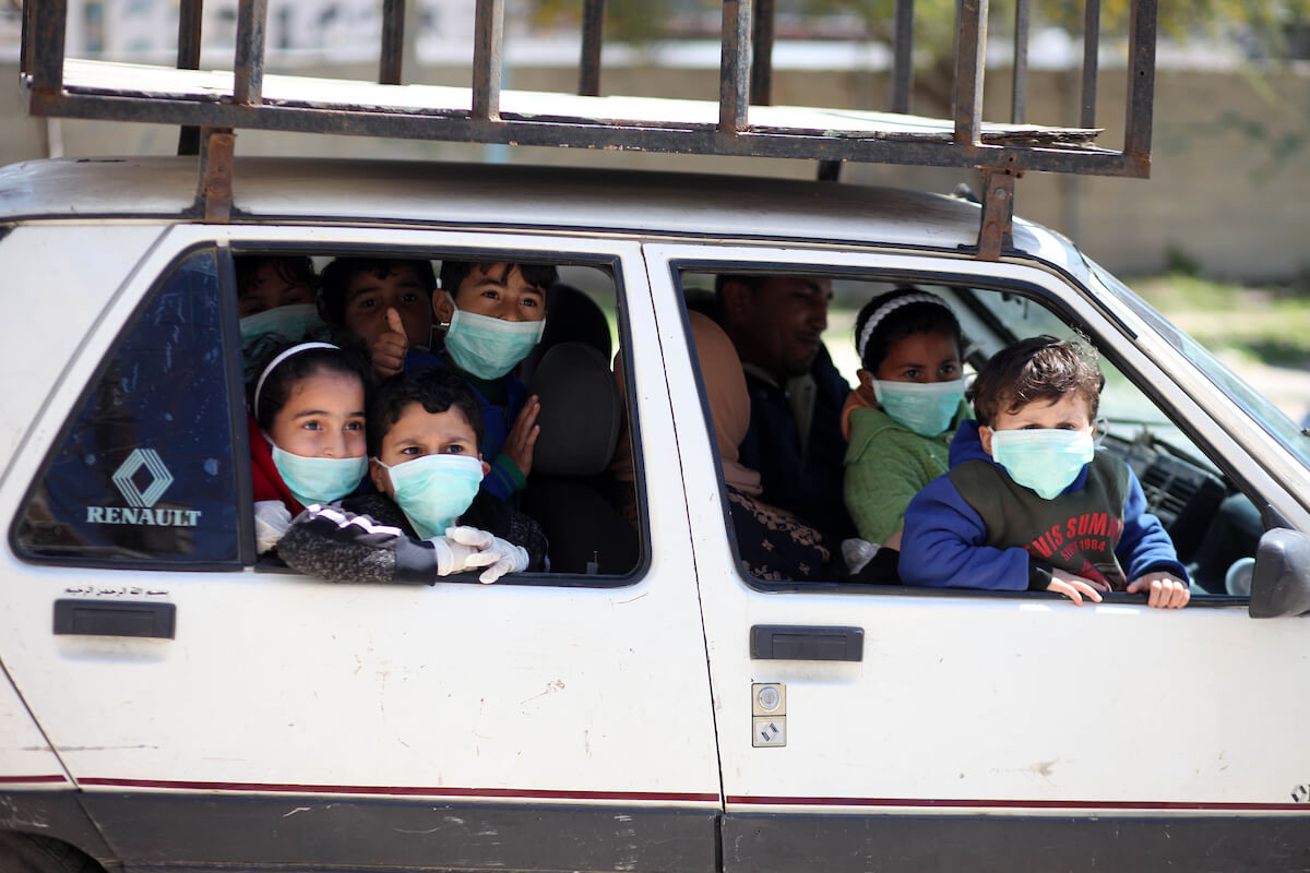Palestinian children wear face masks in Gaza City early on March 22, 2020. Authorities in Gaza confirmed the first two cases of novel coronavirus on Saturday, identifying the individuals as Palestinians who had travelled to Pakistan and were held in quarantine. (Photo: Mahmoud Ajjour/APA Images)