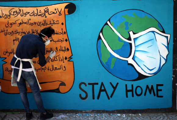 Palestinian artists paint a "stay home" mural in an awareness campaign about the spread of coronavirus disease in Gaza city, on April 2, 2020. (Photo: Mahmoud Ajjour/APA Images)