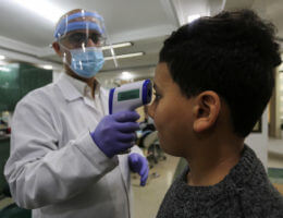 A Palestinian doctor wearing a face shield conducts a medical examination for a patient suspected of having COVID-19 in Gaza City on March 10, 2020. (Photo: Ashraf Amra/APA Images)