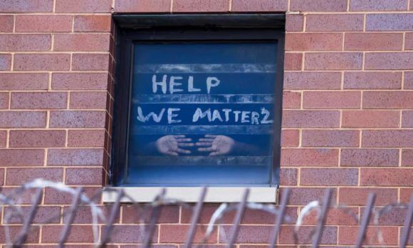 Signs pleading for help are seen in the windows at the Cook county jail complex in Chicago, Illinois, on 9 April. Photograph: Tannen Maury/EPA