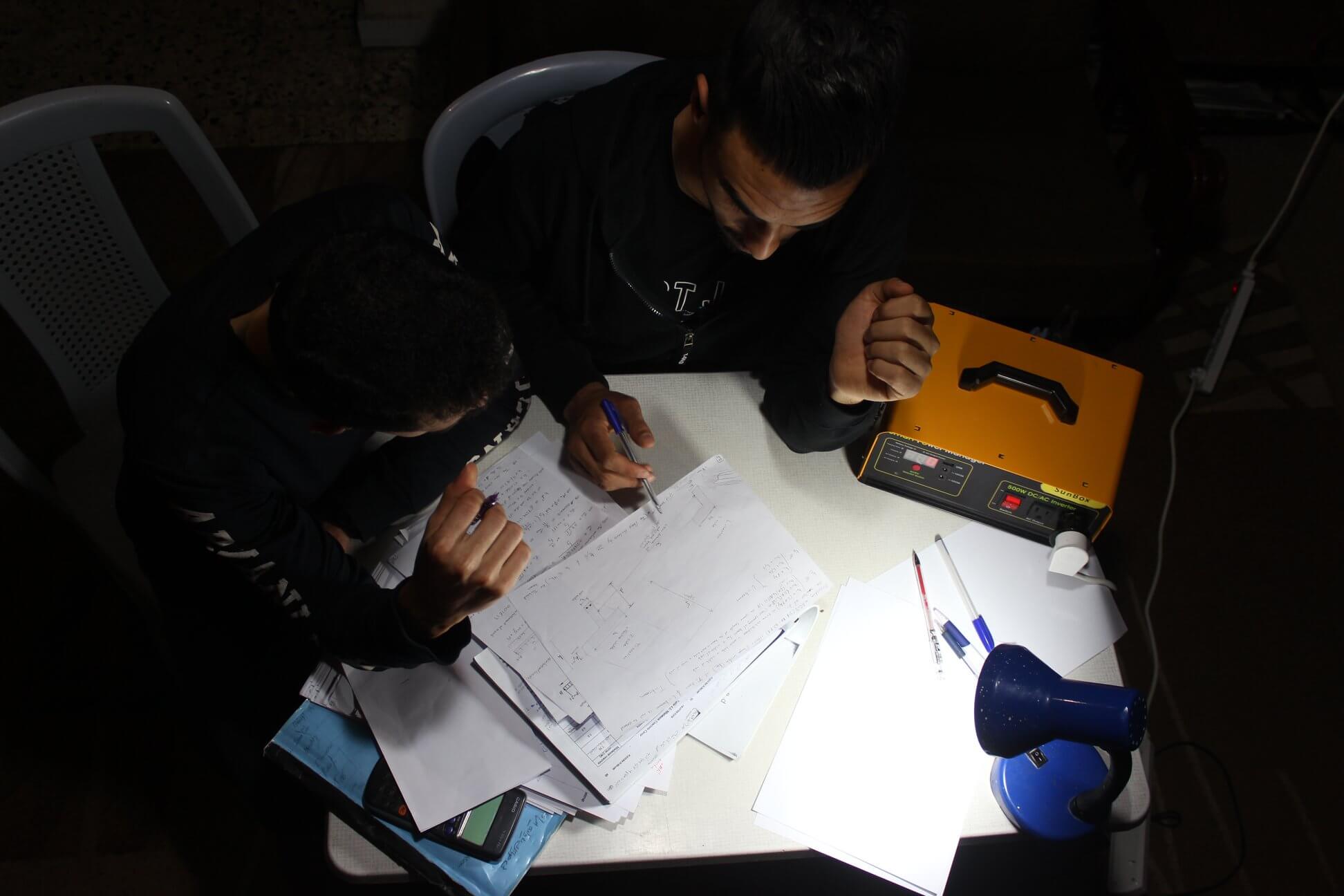 Palestinians use a SunBox to light a lamp in their home. (Photo: SunBox)