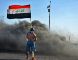 An Iraqi protester holds flag as he takes part in an anti-government demonstration in Iraq's southern city of Nasiriyah in Dhi Qar province on March 1, 2020. (Photo: Wadaa al-Aumry/APA Images)