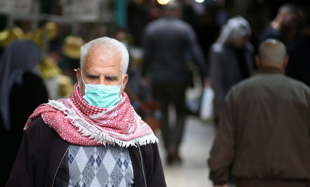 A Palestinian man wearing a protective face mask shops during the Muslim holy fasting month of Ramadan in the West Bank City of Nablus on May 09, 2020. (Photo: Shadi Jarar'ah/APA Images)