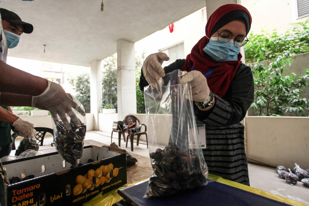 Palestinian volunteers wearing a face mask and gloves as they prepare food parcels for families during during the holy month of Ramadan in Gaza City on April 24, 2020. (Photo: Mahmoud Ajjour/APA Images)