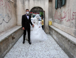 A Palestinian bride and groom wearing masks as a precaution against the spread of COVID-19, during their wedding ceremony in Khan Younis in the southern of Gaza strip on June 11, 2020. (Photo: Ashraf Amra/APA Images)