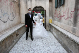 A Palestinian bride and groom wearing masks as a precaution against the spread of COVID-19, during their wedding ceremony in Khan Younis in the southern of Gaza strip on June 11, 2020. (Photo: Ashraf Amra/APA Images)