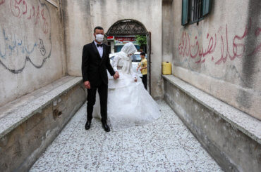 A Palestinian bride and groom wearing masks as a precaution against the spread of COVID-19, during their wedding ceremony in Khan Younis in the southern of Gaza strip on June 11, 2020. (Photo: Ashraf Amra/APA Images)