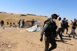 Israeli forces stand by Palestinians homes demolished south of the Yatta village in the southern West bank district of Hebron on June 3, 2020. (Photo: Mosab Shawer/APA Images)
