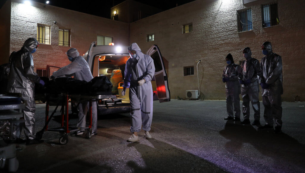 Palestinian health workers move the body of a woman who has died after COVID-19 in the West Bank city of Nablus, July 5, 2020. (Photo: Nablus Governorate Office/APA Images)