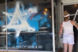 A member of the JDL defacing the Foodbenders storefront (Photo: Twitter)