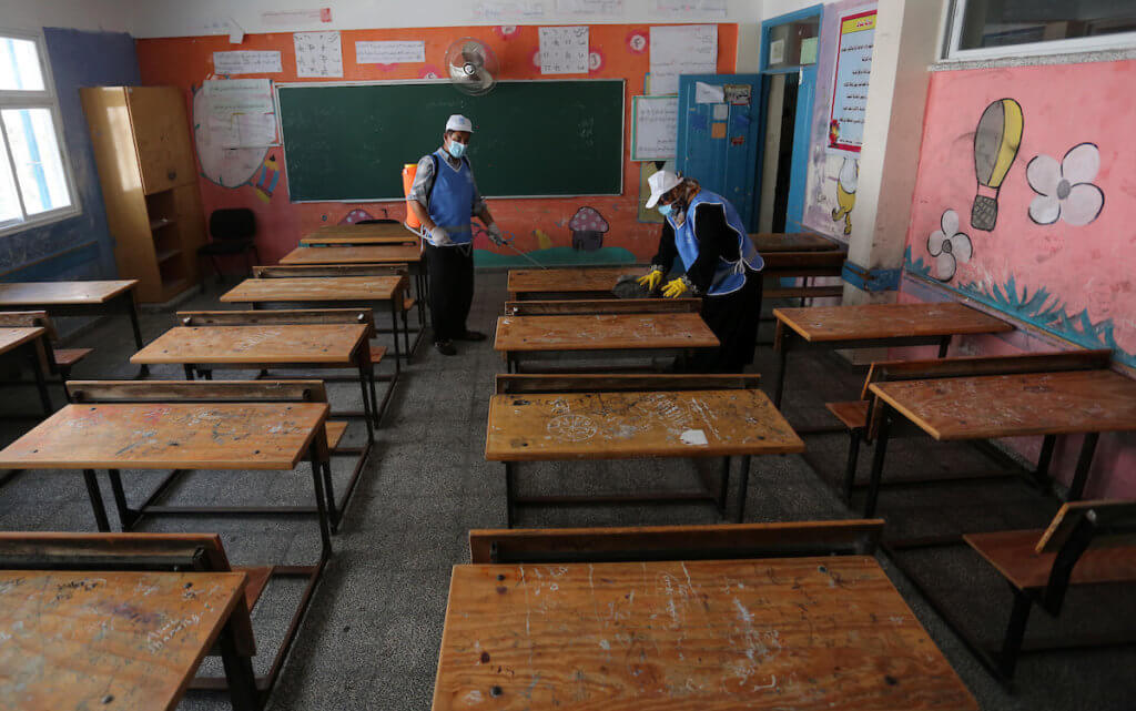 Palestinian workers sanitize a classroom in a United Nations-run school before a new academic year starts, amid concerns about the spread of COVID-19 in Gaza City on August 5, 2020. (Photo: Ashraf Amra/APA Images)