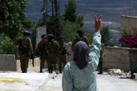 A Palestinian woman flashes a victory sign as she shouts at Israeli forces following a protest against the expropriation of Palestinian land on July 19, 2013 in the village of Kfar Qaddum, near the occupied West Bank city of Nablus. (Photo: Nedal Eshtayah/ APA Images)