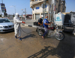 Palestinian health workers spray disinfectant on vehicles entering the Maghazi refugee camp as a precaution against the spread of the coronavirus in the central Gaza Strip on September 1, 2020. (Photo: Ashraf Amra/APA Images)
