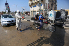 Palestinian health workers spray disinfectant on vehicles entering the Maghazi refugee camp as a precaution against the spread of the coronavirus in the central Gaza Strip on September 1, 2020. (Photo: Ashraf Amra/APA Images)