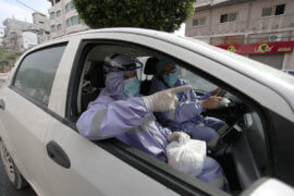 Palestinian nurses from the United Nations Relief and Works Agency for Palestinian Refugees wear protective gear as they distribute monthly medications for chronic illnesses in Gaza City on September 3, 2020. (Photo: Mahmoud Ajjour/APA Images)