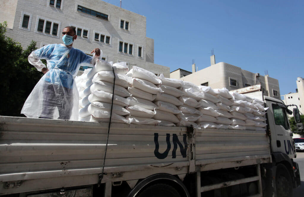 UNRWA employees wearing protective masks and gloves, transport food aid to refugee family homes, amid the coronavirus disease (COVID-19), in Gaza City, on September 15, 2020. (Photo: Mahmoud Ajjour/APA Images)