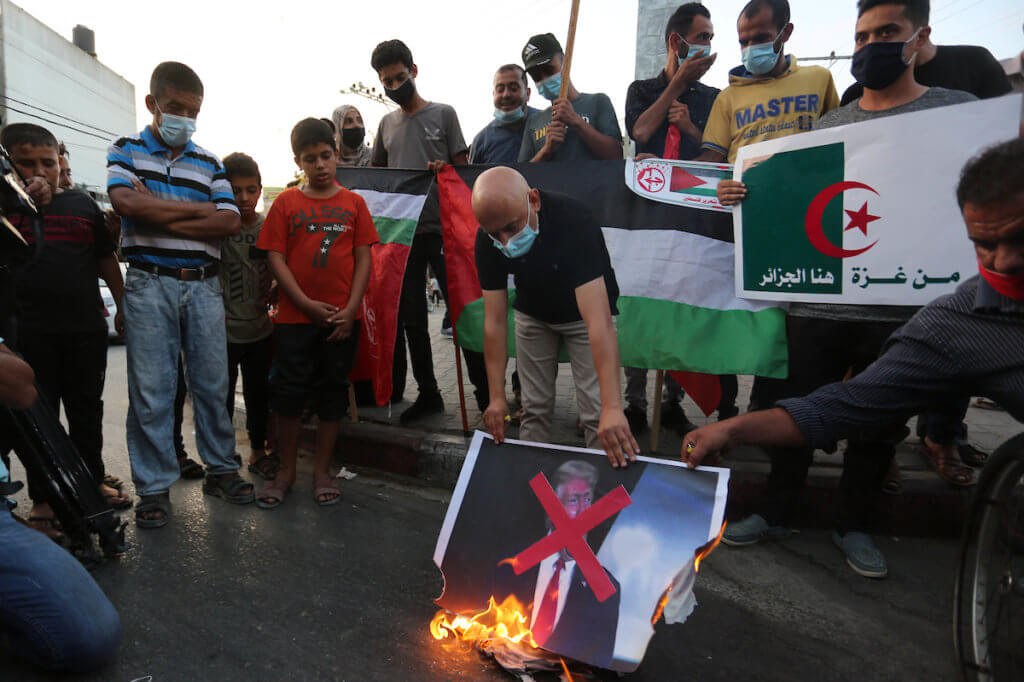 Palestinian protesters burn a portrait of US President Donald Trump during a protest in Khan Yunis in the southern Gaza Strip on September 23, 2020, to denounce the Israeli normalization deals with the United Arab Emirates and Bahrain. (Photo: Ashraf Amra/APA Images)