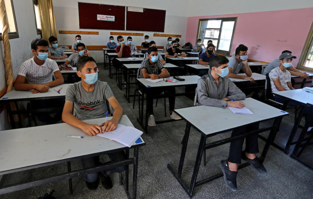 Palestinian students wearing face masks take part in a simulation of returning to schools, as a preventive measure to slow the spread of the coronavirus, organized by the Ministry of Education in Khan Younis in south Gaza on October 4, 2020. (Photo: Ashraf Amra/APA Images)
