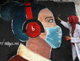 Palestinian artist paints a mural to raise awareness on wearing face masks amid the coronavirus pandemic in Gaza City on October 22, 2020. (Photo: Mahmoud Ajjour/APA Images)