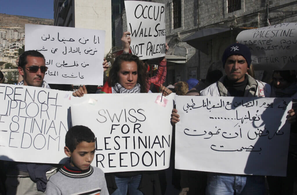 Palestinian and activists hold placards during a gathering to mark the International Day of Solidarity with the Palestinian People on November 29, 2011 in the West Bank city of Nablus. (Photo: Wagdi Eshtayah/APA Images)