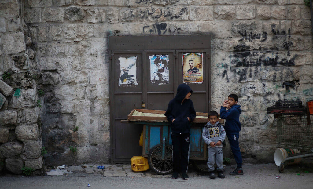 Palestinians children stand in a closed market as authorities announced a lockdown on weekends to curb the spread of COVID-19 in the West Bank city of Nablus on November 28, 2020. (Photo: Shadi Jarar'ah/APA Images)